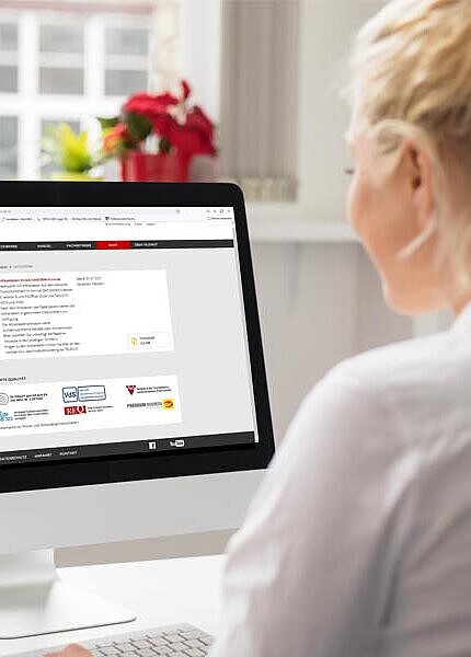 Mitarbeiterin schaut im Büro auf ihrem PC die Download-Seite an