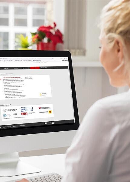 Mitarbeiterin schaut im Büro auf ihrem PC die Download-Seite an