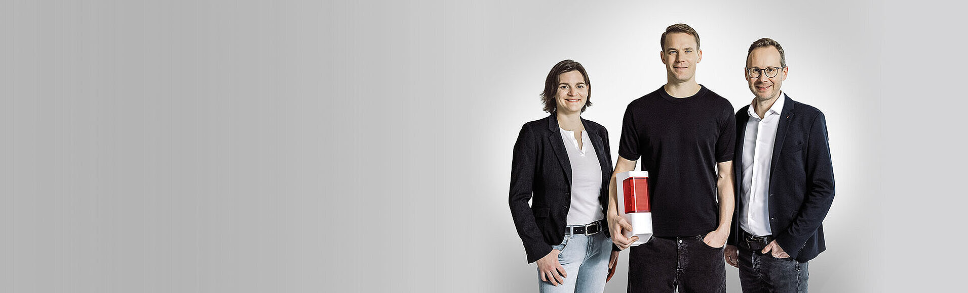 Manuel Neuer steht zwischen den Geschäftsführern Anja Wunderle und Dr. Timo Stock.